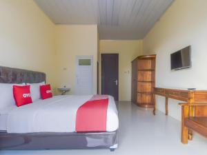 班达楠榜OYO Life 3365 Griya Nusantara Syariah的一间卧室配有一张带红色枕头的大床