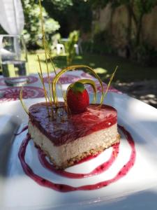 萨尔塔Samsara Hotel Salta的一块带草莓的蛋糕,放在一个白色的盘子上