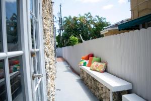 迈阿密Relax and Unwind in Little Havana - 2K的围栏旁的长凳,配有色彩缤纷的枕头