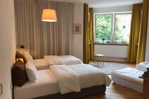 奥格斯堡Charmant Leben im Textilviertel - stilvolle Wohnung - zentral und ruhig的酒店客房设有两张床和窗户。