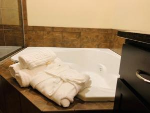 Watford CityRoosevelt Inn & Suites的带浴缸和毛巾的浴室