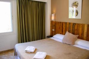 马略卡岛帕尔马利斯马洛卡酒店的一间卧室配有一张床,上面有两条毛巾