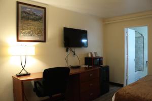 楠帕南帕市中心酒店的酒店客房配有书桌、床和电视。
