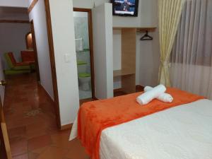 莱瓦镇Apartahotel La Gran Familia的酒店客房设有一张带电视的床,客房