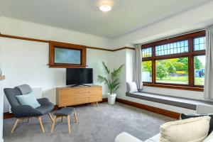 布伦海姆Stylish on Severne的客厅配有电视、沙发和窗户。
