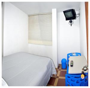 Urbanizacion Buenos AiresHospedaje La Casa Blanca的卧室配有一张床,墙上配有电视。