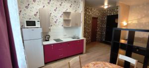 新西伯利亚Апартаменты на Челюскинцев 3的小厨房配有白色冰箱和紫色橱柜