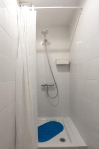 利马索尔Bee Hostel的白色的浴室设有蓝色地毯和淋浴