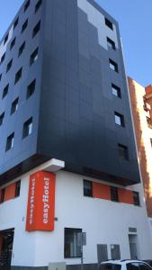 马拉加easyHotel Malaga City Centre的一座高大的建筑,上面有橙色的标志