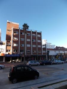 埃斯特角城Punta del Este Shelton Hotel的停在大楼前的一辆黑色汽车