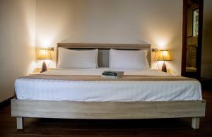丽贝岛丽贝岛壁虎度假酒店的一张带两个枕头的床和一本书