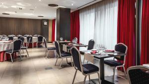 塔拉韦拉·德·拉·雷纳塔拉韦拉市中心比利酒店的一间配备有桌椅和红色窗帘的用餐室