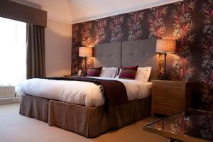 梅尔罗斯陶恩豪斯酒店的一间卧室配有一张大床和大床头板