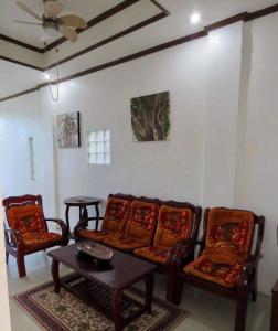 塔奈Perlies Inn Balcony House的客厅配有沙发、两把椅子和一张桌子