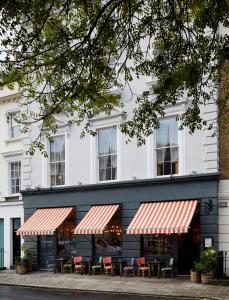 伦敦伦敦艺术家酒店的大楼前设有桌椅的餐厅