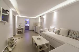 卡马利阿基里斯公寓酒店的客厅配有沙发和桌子