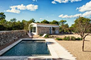 阿莱奥尔Menorca Experimental的一座带石墙的房屋后院的游泳池