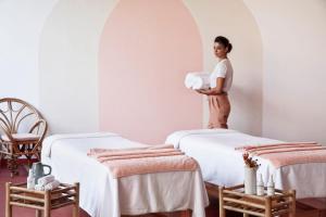 阿莱奥尔Menorca Experimental的一位妇女站在带两张床的房间