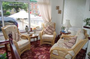 莱瑟姆-圣安妮霍林沃思住宿加早餐旅馆的客厅配有椅子、桌子和窗户