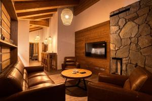 迪马诺卡多林纳DaSus Lux&Wellness Apartments Sosana的客厅配有皮革家具和石墙
