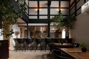 金泽HOTEL 101 KANAZAWA的餐厅设有酒吧,配有桌椅