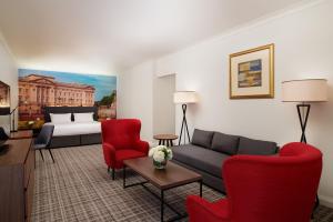 伦敦千禧国际伦敦格洛斯特酒店的客厅配有沙发、椅子和1张床