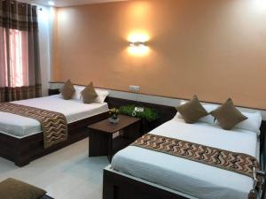 ItahariYara Hotel的酒店客房设有两张床和一张桌子。
