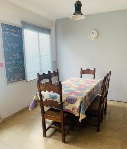萨尔塔Casa en el centro de Salta - Casaguemessalta的餐桌、两把椅子和黑板