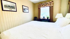 东斯特劳兹堡肖尼酒店和高尔夫度假村的卧室配有白色的床和窗户。