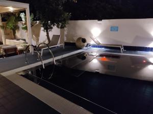 塔兰托Aparthotel Masseria Villa Marchesi的夜间在房子里带灯的游泳池