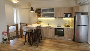 MonoliaSkinari Apartments的厨房配有木制橱柜和不锈钢冰箱。