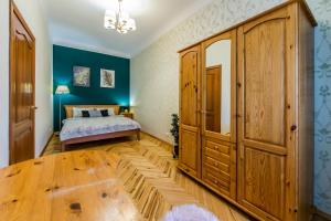 基辅Затишна квартира на Майдані Незалежності的一间卧室配有一张床和一个大型木制橱柜