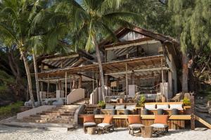 Nosy MitsioConstance Tsarabanjina - All Inclusive的海滩上的度假村,设有椅子和棕榈树