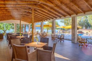 耶尼翁克利欧佩特拉海滩旅馆的一间带桌椅的餐厅和一个游泳池