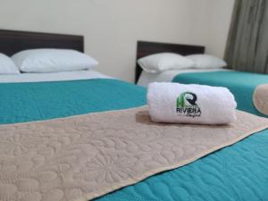 帕斯托Hotel Riviera Confort的两张床,上面有毛巾