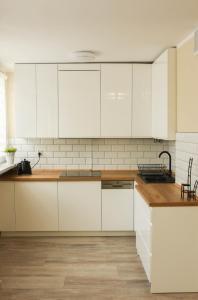 杰尔若纽夫Apartament Studio Klasztorna的厨房配有白色橱柜和木制台面