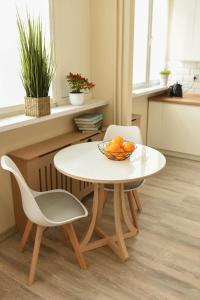 杰尔若纽夫Apartament Studio Klasztorna的桌子和两把椅子以及一碗橙子