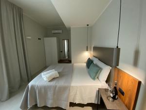 贾迪尼-纳克索斯Villa Antonino的卧室配有一张白色的大床和一张桌子