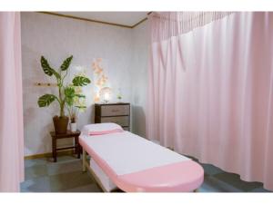 鹿儿岛Hotel Taisei Annex - Vacation STAY 04735v的一间医院房间,配有粉红色的床和窗帘