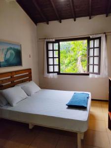 瓜尔达恩巴Nalua Guest House的一间卧室设有一张大床和窗户