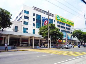 马尼拉Go Hotels Otis - Manila的一条城市街道上的大型建筑,前面有汽车