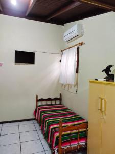 瓜尔达恩巴Nalua Guest House的一间卧室配有一张带彩色毯子的床