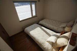 远轻町Farm Stay Ezura Farm的一间小卧室,配有两张床和窗户