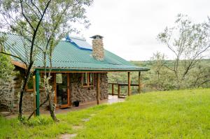 奈瓦沙Honeymoon Hut的一座带绿色屋顶的小石头房子