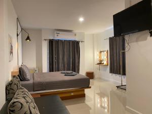 考科M Hostel And Cafe at Khao Kho的一间卧室配有一张床和一台平面电视