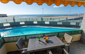 圣阿古斯丁Las Burras Beach terrace&pool By CanariasGetaway的游泳池旁的一张桌子和一碗水果