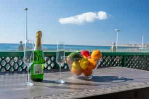 圣阿古斯丁Las Burras Beach terrace&pool By CanariasGetaway的一张桌子,上面放着一碗水果和两杯酒杯