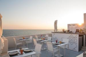滨海波利尼亚诺Dimora Talenti的海景餐厅,配有桌椅