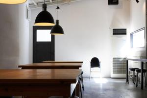 上田市hostel mog的用餐室配有木桌和黑色吊灯