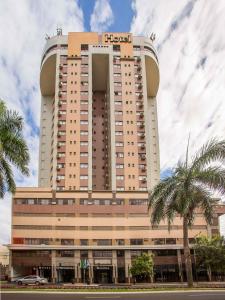 马林加玛琳加梅特罗普尔酒店的一座高大的建筑,前面有棕榈树